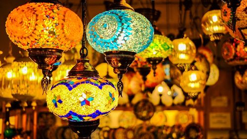 Close-up of illuminated lanterns hanging at store for sale