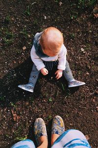 Low section of mother by daughter standing on ground