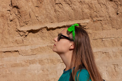 Portrait of woman standing against wall