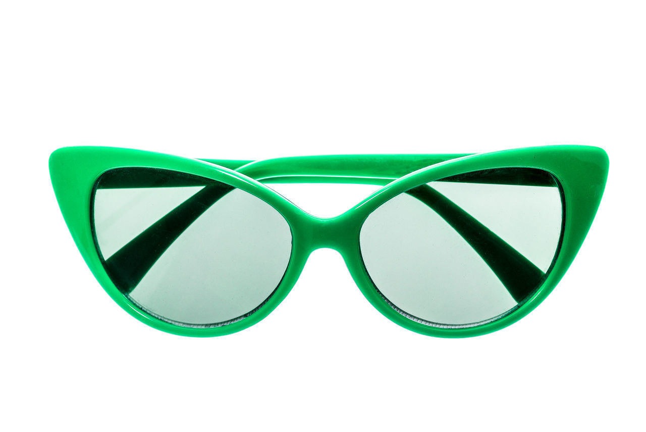CLOSE-UP OF SUNGLASSES ON GREEN WALL