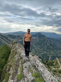 Full length of man standing on rock against sky