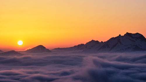 Scenic view of snowcapped mountains against sky during sunset