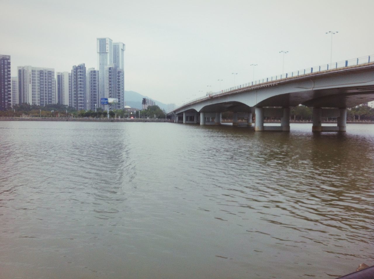 architecture, built structure, water, building exterior, waterfront, bridge - man made structure, river, connection, city, clear sky, bridge, reflection, sky, building, outdoors, day, rippled, no people, engineering, cityscape