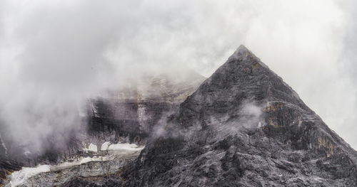 Low angle view of mountain against cloudy sky