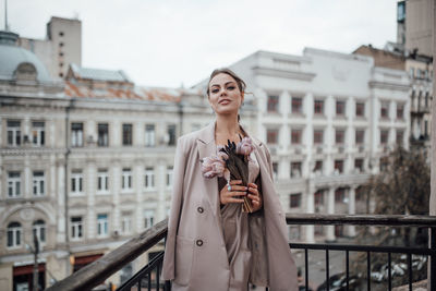 Woman standing against building in city