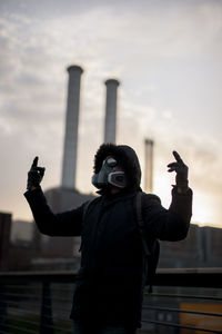 Portrait of survived man standing with mask against sky after corona virus covid19 outbreak