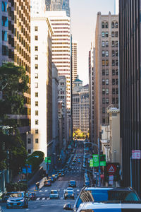 Traffic on road amidst buildings in city