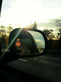 Reflection of woman on side-view mirror of car