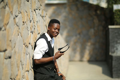 Young man standing against wall