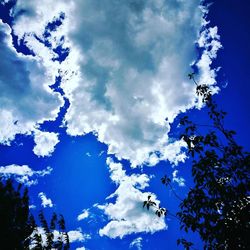 Low angle view of birds against blue sky