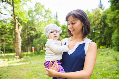 Portrait of mother and daughter standing against plants