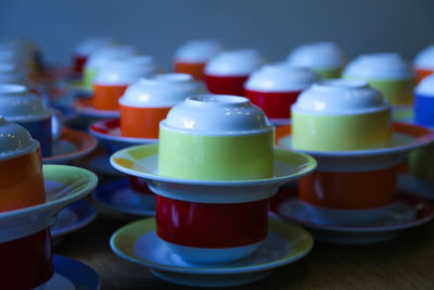 Close-up of colorful cups and saucers on table