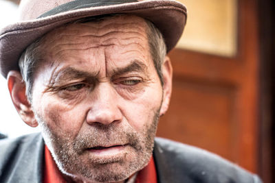 Close-up of senior man wearing hat while looking away