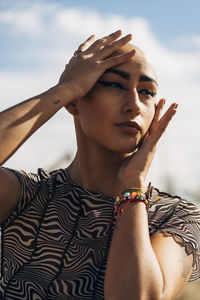 Thoughtful woman with head in hands on sunny day