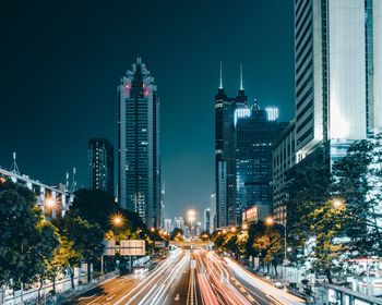 Illuminated city against clear sky at night