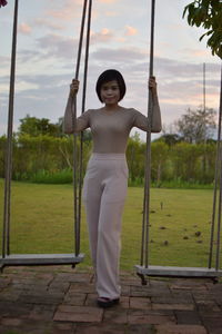 Portrait of smiling young woman standing on field