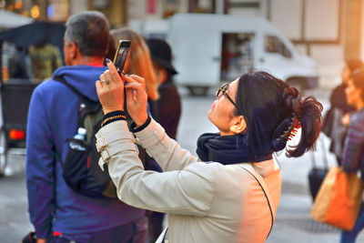 Rear view of man and woman using mobile phone