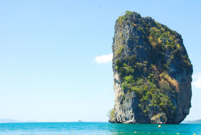 Rock formation in sea against sky