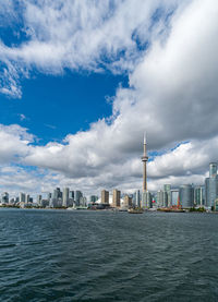 Sea and buildings in city against sky