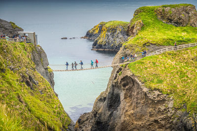 People on rock by sea