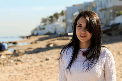 Portrait of young woman standing at beach