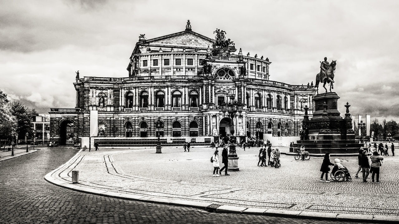 GROUP OF PEOPLE IN FRONT OF HISTORICAL BUILDING IN CITY