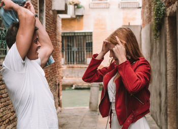 Young couple standing against buildings