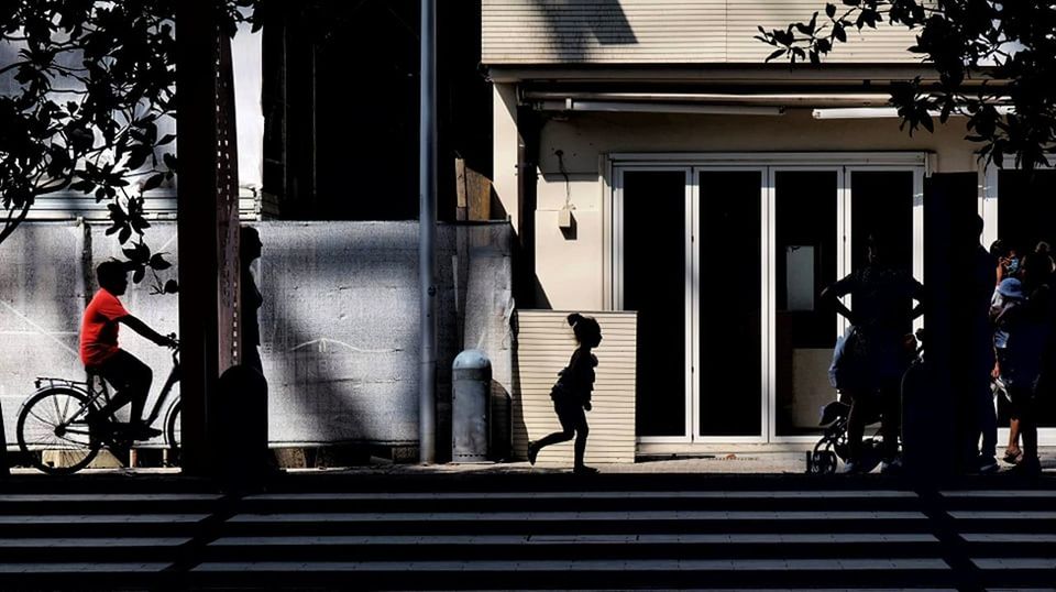 PEOPLE WALKING ON STREET AMIDST BUILDINGS