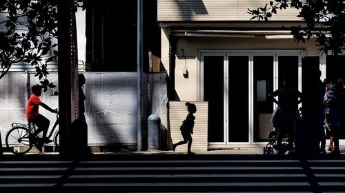 People walking on street amidst buildings in city