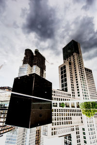 Low angle view of modern building against cloudy sky