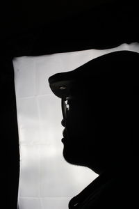 Portrait of young woman against black background
