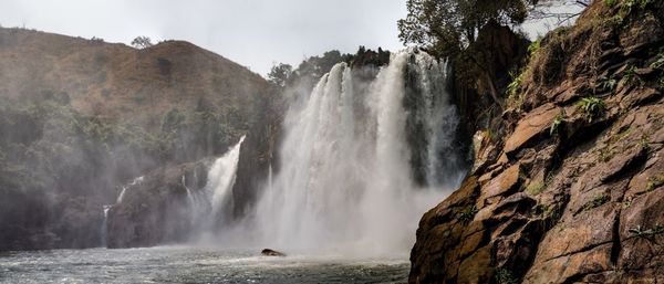 Scenic view of waterfall against sky