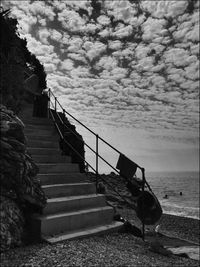 Staircase on beach against sky