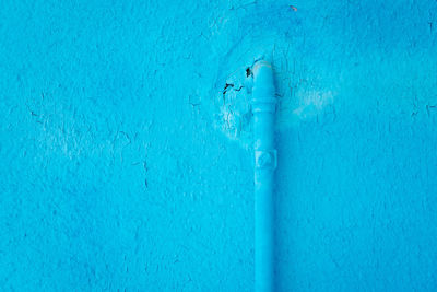 Close-up of pipe on blue wall of house in burano
