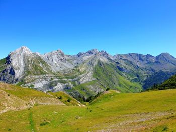 Scenic view of snowcapped mountains against clear blue sky