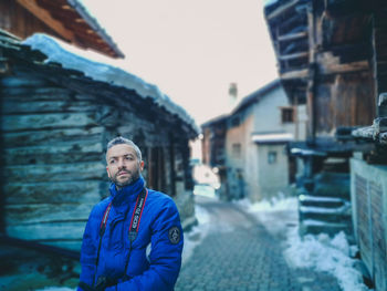 Portrait of young man standing in city during winter