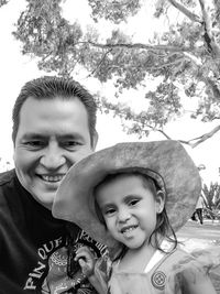 Portrait of happy mother and daughter against trees