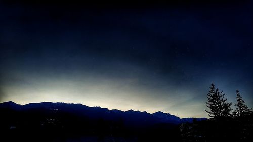 Scenic view of silhouette mountains against sky at night