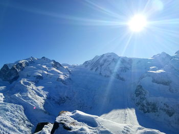 Scenic view of snowcapped mountains against blue sky