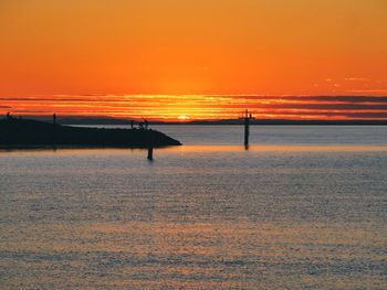 Scenic view of sea against orange sky