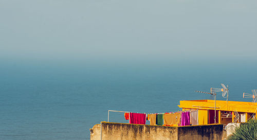 Built structure by sea against clear sky