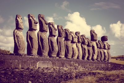 Sculpture of statues against cloudy sky