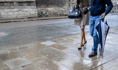 Low section of people walking in rain