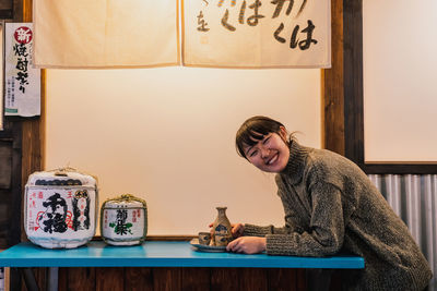 Portrait of smiling young woman on table