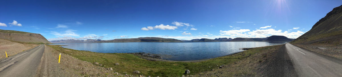 Panoramic view of road by lake against sky