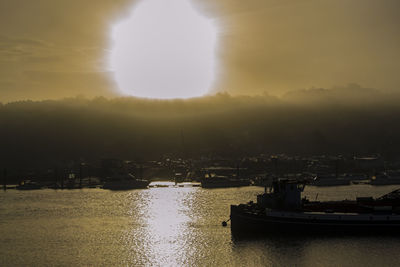 Boats in river at sunset