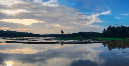 Scenic view of lake against sky at sunset