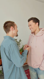 Side view of couple standing against white background