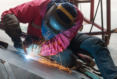 Worker welding metal grate