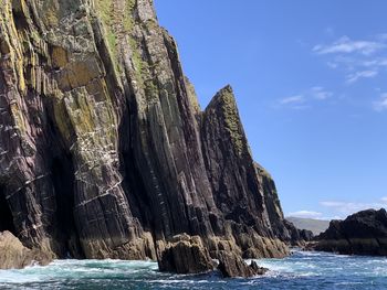 Rock formation in sea against sky